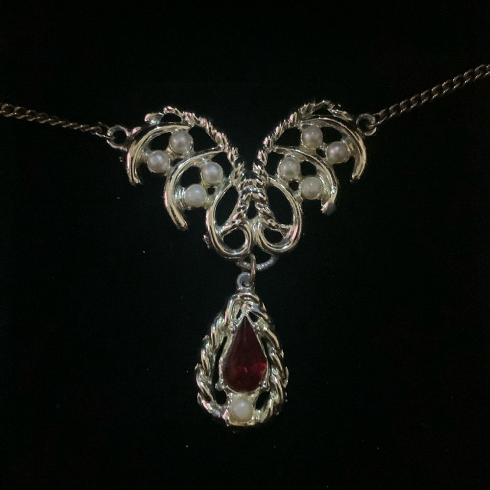 Silver tone necklace with pearls and dark red rhinestone